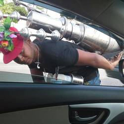 Roadside date syrup vendor, bending over to pour a cup