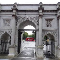 Red double decker bus through the Marble Arch