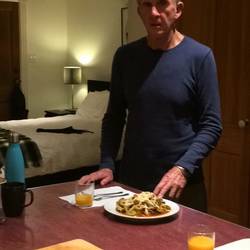 Neil with dinner and our bedroom behind.