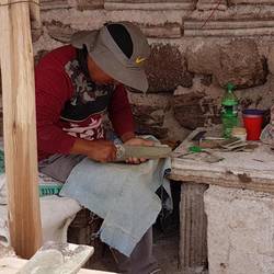 A local artisan carving on stone