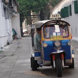 Double John, tout sourire dans un tuk tuk.