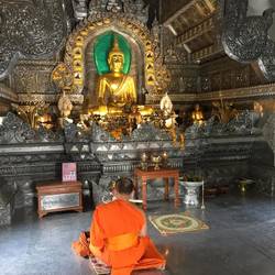 Monk praying in silver temple