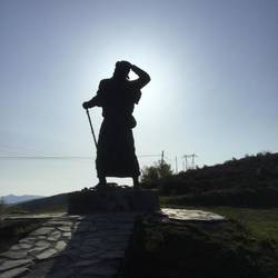 A Pilgram statue at the top of a mountain. Very artistic with the sun behind the statue I think!