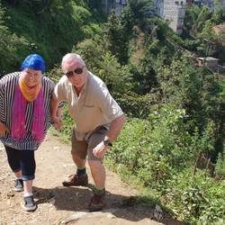 John helping Carol up the hill. Carol has worn her best hiking gear today.