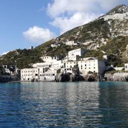 Türkises Wasser vor weißen Ruinen vom Bimssteinabbau