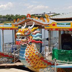 Dragon boats line the edge of the riverside.