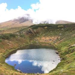 Mountain pond with steam vents of Mount Asahidake.