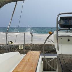 Wellen spritzen über die Mole und laufen in den Hafen