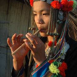 A Nuqui Akha girl plays her mae lii mae lo whistle flute during courting. (Laos)