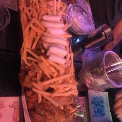 Onder een berg frieten (en rice cakes?) bevindt zich fried chicken!