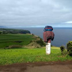 Workman's sweater and lunchpail on a post
