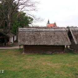 Hier wird ein Wikingerdorf rekonstruiert. Im Hintergrund die mächtige Kirche von Wolin