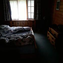 Tim still asleep in our room with the lace curtains letting in morning light