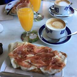 Cafe con leche, zumo natural y tostada con jamon, queso y tomate