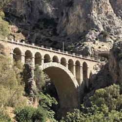 Train travels through the mountains and across this bridge