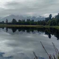 Reflections of mountains, trees and clouds