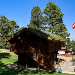 The grass-roofed "stabbur" was built in Norway and reconstructed here ... Chapel in the Hills.