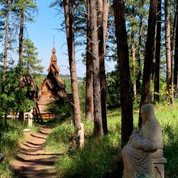 "Pray for Children" statue with the stavkirke in the background — Rapid City, SD.
