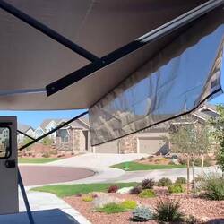 The short, permanent piece of the shade curtain rolls up with the awning.