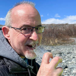 Deniz tasting crystal clear glacier ice — Knik Glacier Tour, AK.