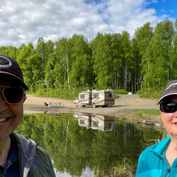 A "we are at Olnes Pond with our RV & toad" selfie — Olnes Pond in Fairbanks, AK.