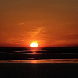 The sun sizzling into the sea