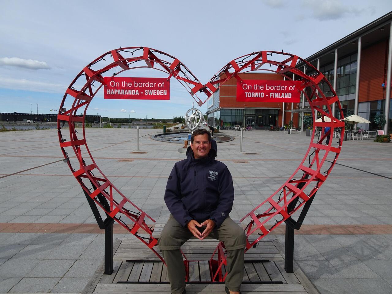 Sitzen auf der Grenze: mit dem rechten Bein im schwedischen Haparanda, mit dem linken im finnischen Tornio