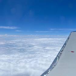 Blue skies and fluffy white clouds ... and spots on the porthole — Aboard UA4660.