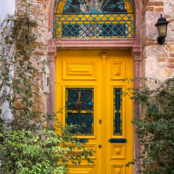 A bright, cheery yellow door welcomes visitors — Ayvalık, Balıkesir.