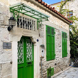 Traditional stone house with colorful door & shutters — Eski Foça, İzmir.