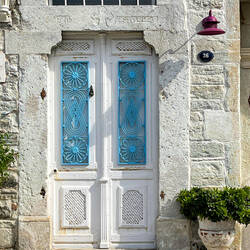 A kitty cat napping in front of an interesting door — Eski Foça, İzmir.
