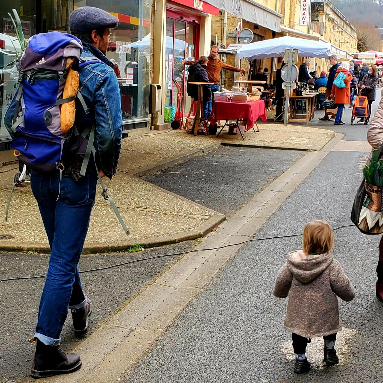 Not only is the baby adorable, the dad is, too, with his backpack of leeks and half eaten baguette