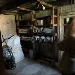 Small storage room in the older part of the house, with stacjed milk churns
