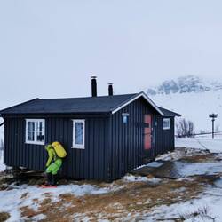 Hiding behind the hut to be protected from the wind while putting on snowshoes