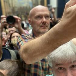 Prople pushing, leaning over, doing whatever they could to get past