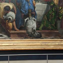 A cat playing with a wine jug