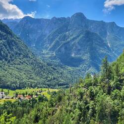 Am Dorf sieht man die gewaltige Höhe der dahinter liegenden Berge