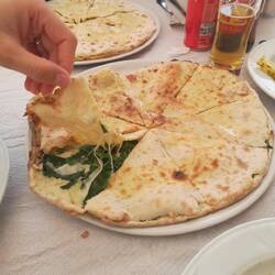 Eigenkreation von den Besitzern - geteilter Pizzaboden mit Käse und Spinat.