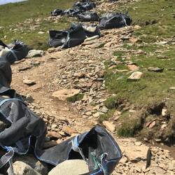 Bags of stone beside the loose surface path ready for laying