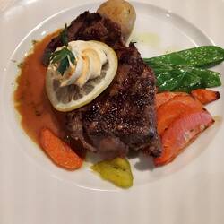 Sirloin Steak "Cafe de Paris" mit Knoblauchjus, Zuckerschoten und jungen Kartoffeln
