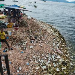 Die Menschen sitzen auf einem Berg voller Muscheln