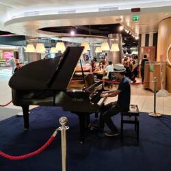 Caden playing the piano in the Rome Airport