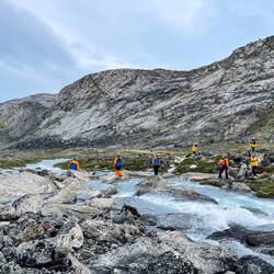 The creek crossing, with expedition members standing by to help us cross — Eqip Sermia, Greenland.