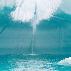 Inside the ice cave we find a stream of water plunging into the water — Ilulissat, Greenland.