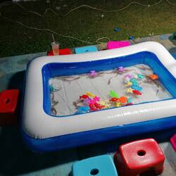 Spiel für Kinder: Sie sollen die Formen aus dem Wasser fischen. Im Becken sind auch echte Fische.