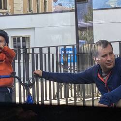 Cute kid saying goodbye to his mom with a heart sign.