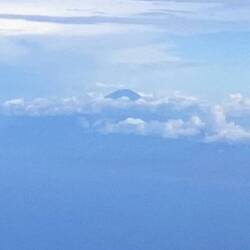 A lone mountain top popping thru the clouds