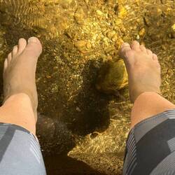 Soaking my sore feet in the freezing river behind Casa Susi