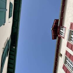 Looking up from our table - gorgeous blue sky with the red and green shutters