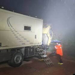 Installing a hydraulic tube late at night in pouring rain.